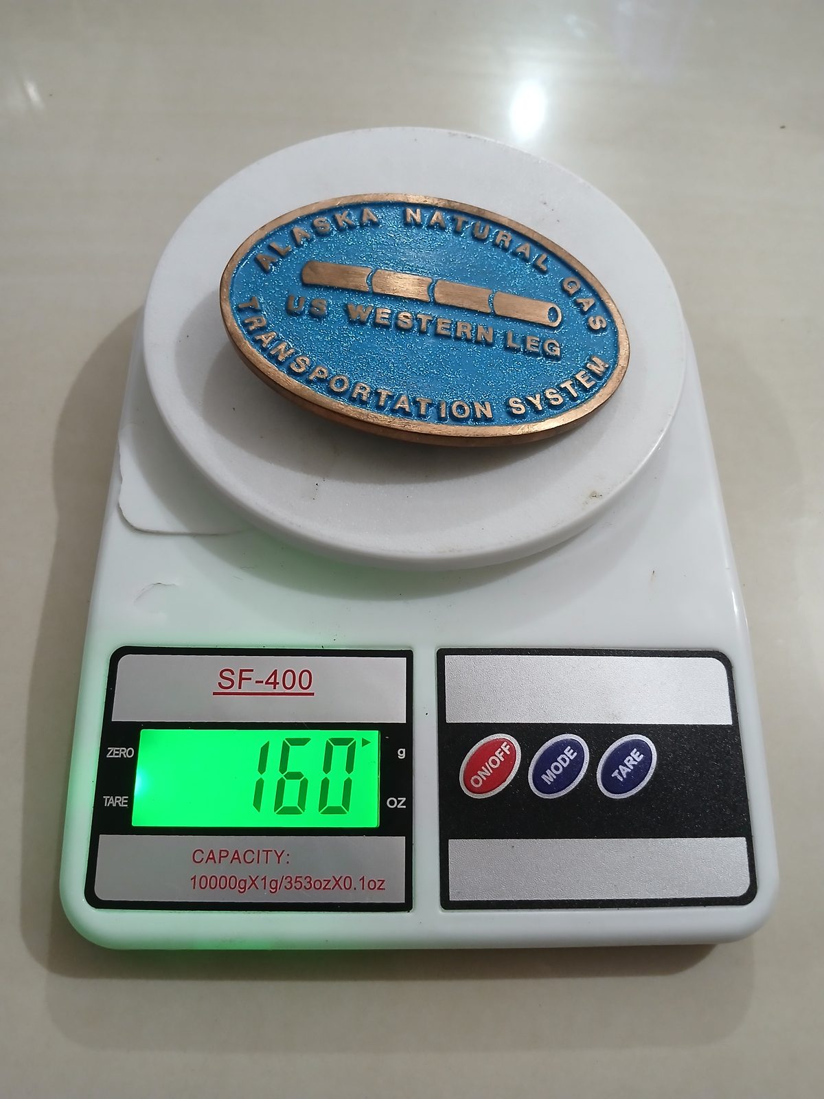 Alaska Natural Gas US Western Leg Vintage Belt Buckle – On scale showing weight Alaska Natural Gas US Western Leg vintage belt buckle – on scale showing weight