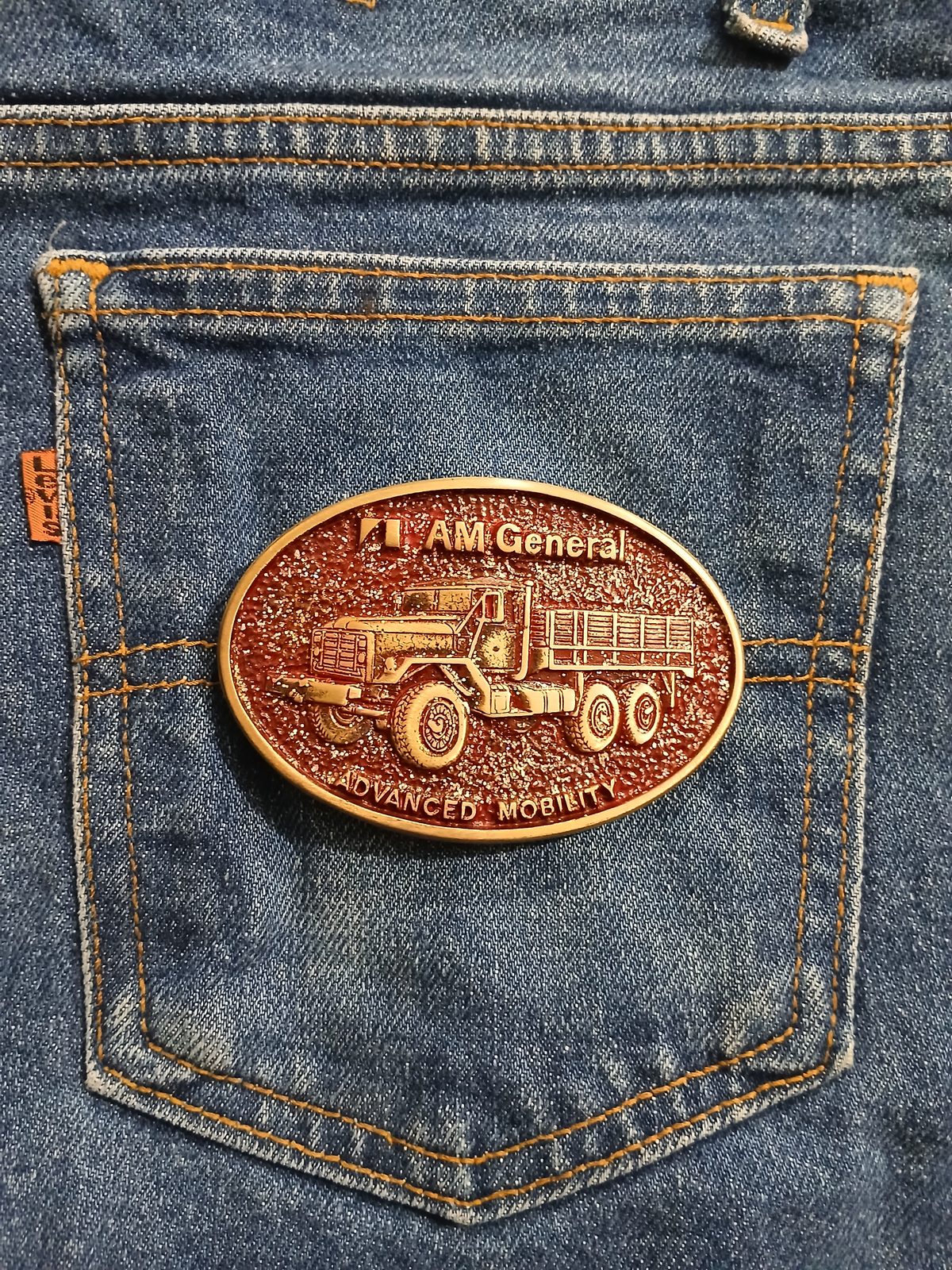 AM General Advanced Mobility Vintage Belt Buckle – On jeans back pocket AM General Advanced Mobility vintage belt buckle – on jeans back pocket