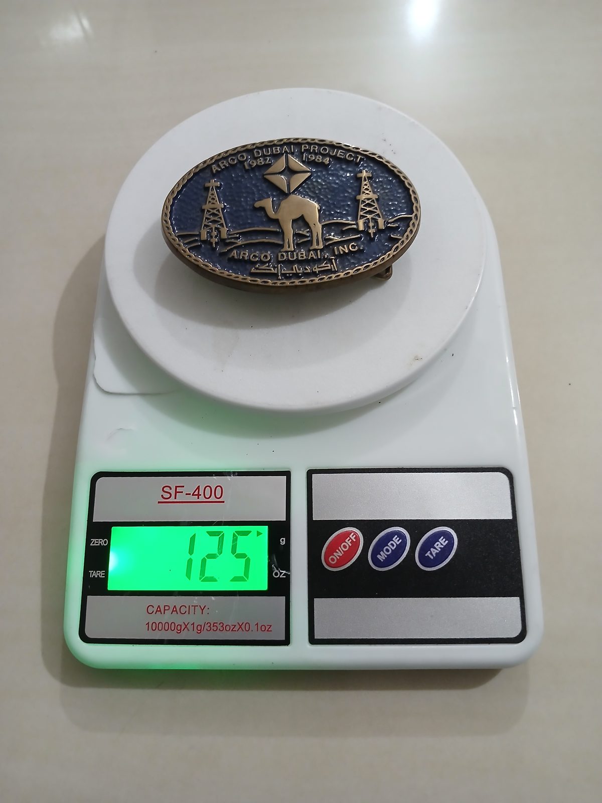 ARCO Dubai Inc Camel Vintage Belt Buckle – On scale showing weight ARCO Dubai Inc Camel vintage belt buckle – on scale showing weight