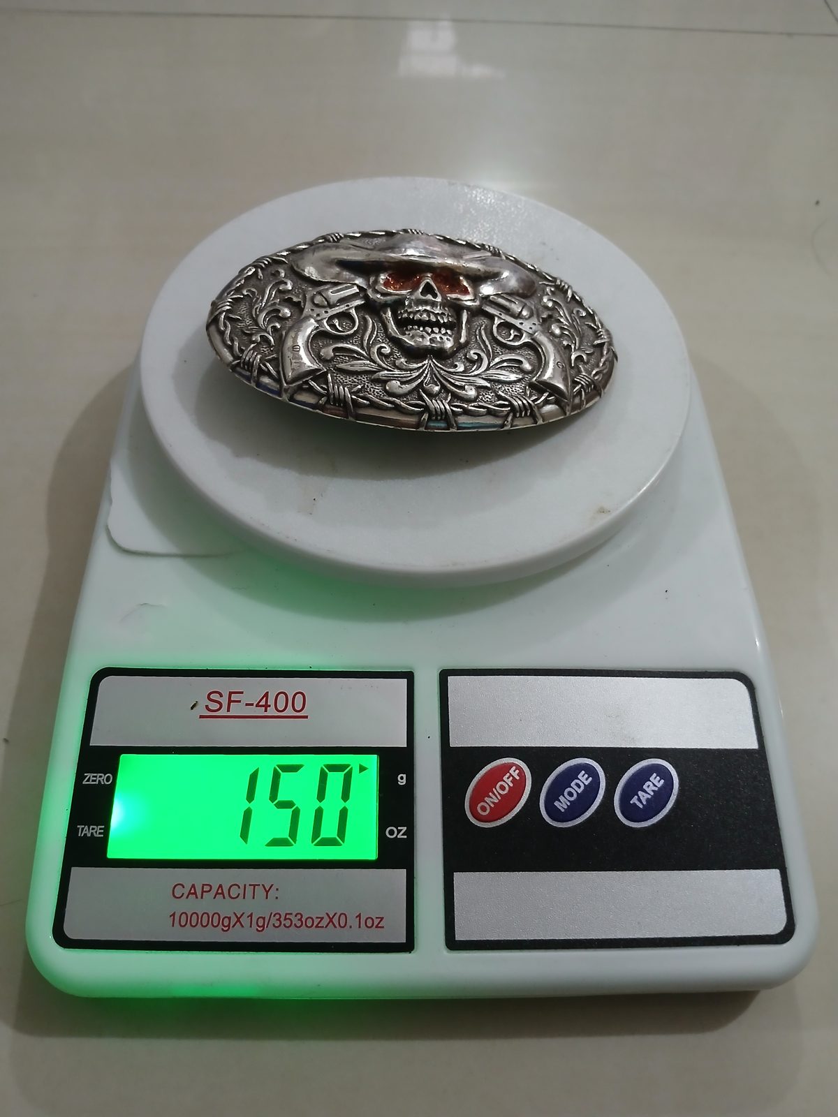 Cowboy Skull Pistols Vintage Belt Buckle – On scale showing weight Cowboy Skull Pistols vintage belt buckle – on scale showing weight