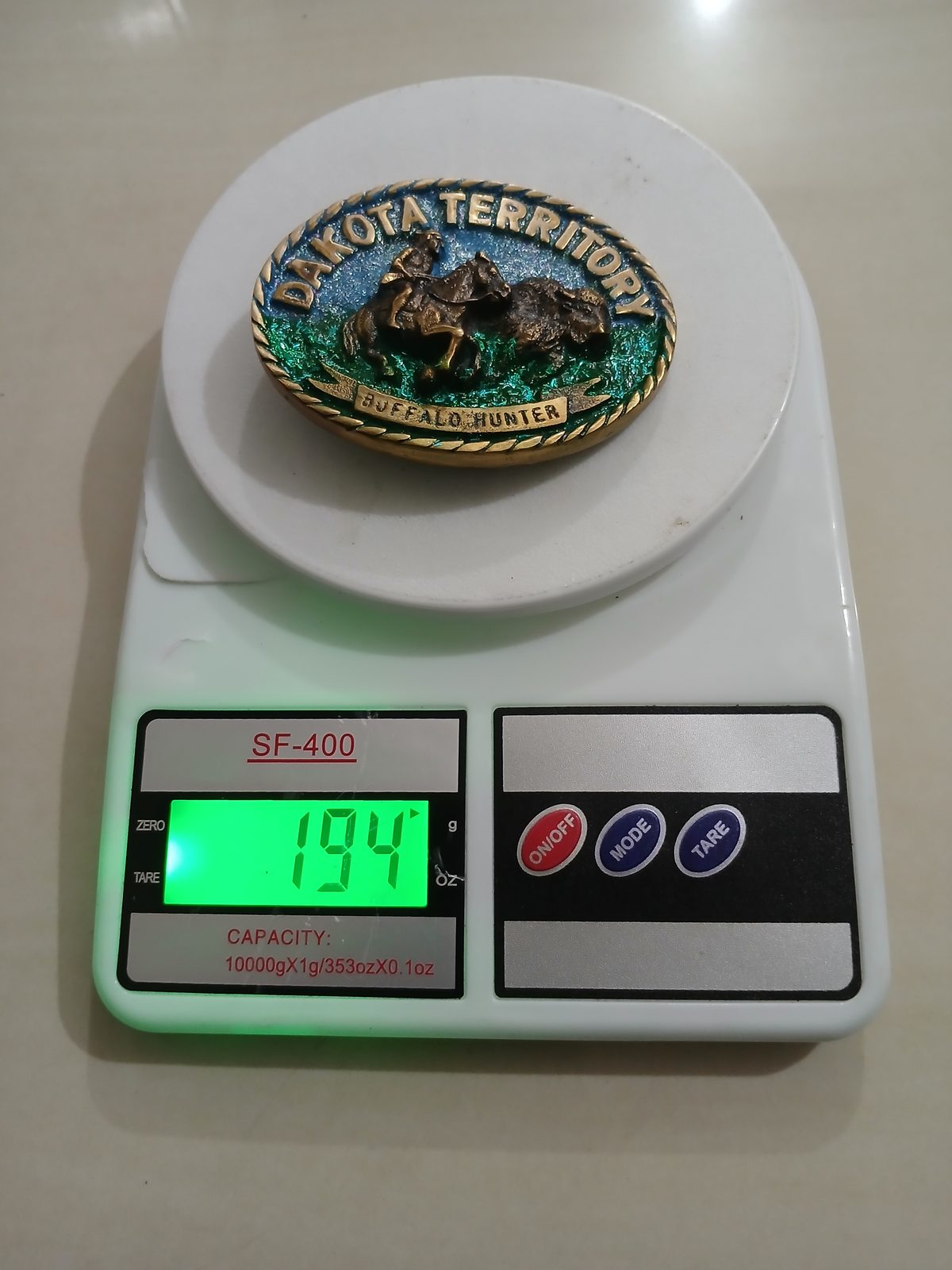 Dakota Territory Buffalo Hunter Vintage Belt Buckle – On scale showing weight Dakota Territory Buffalo Hunter vintage belt buckle – on scale showing weight