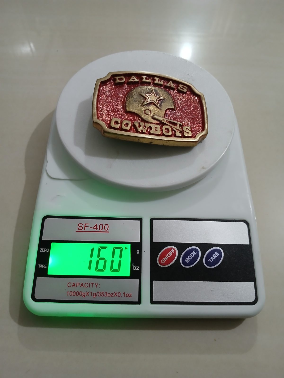 Dallas Cowboys Helmet Vintage Belt Buckle – On scale showing weight Dallas Cowboys Helmet vintage belt buckle – on scale showing weight