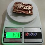 Electrician vintage belt buckle – on scale showing weight