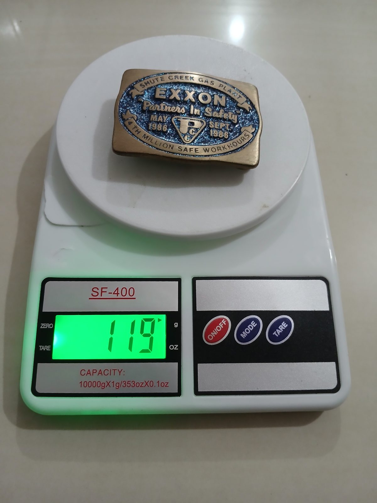 Exxon Partners In Safety 1986 Vintage Belt Buckle – On scale showing weight Exxon Partners In Safety 1986 vintage belt buckle – on scale showing weight
