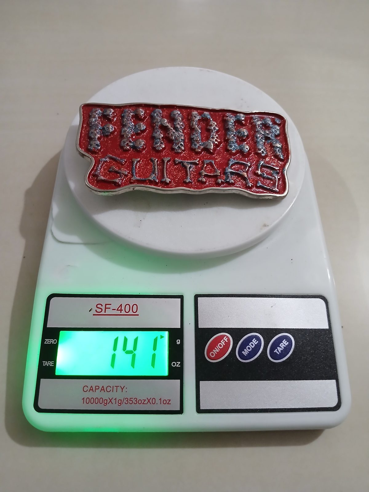 Fender Guitars Vintage Belt Buckle – On scale showing weight Fender Guitars vintage belt buckle – on scale showing weight