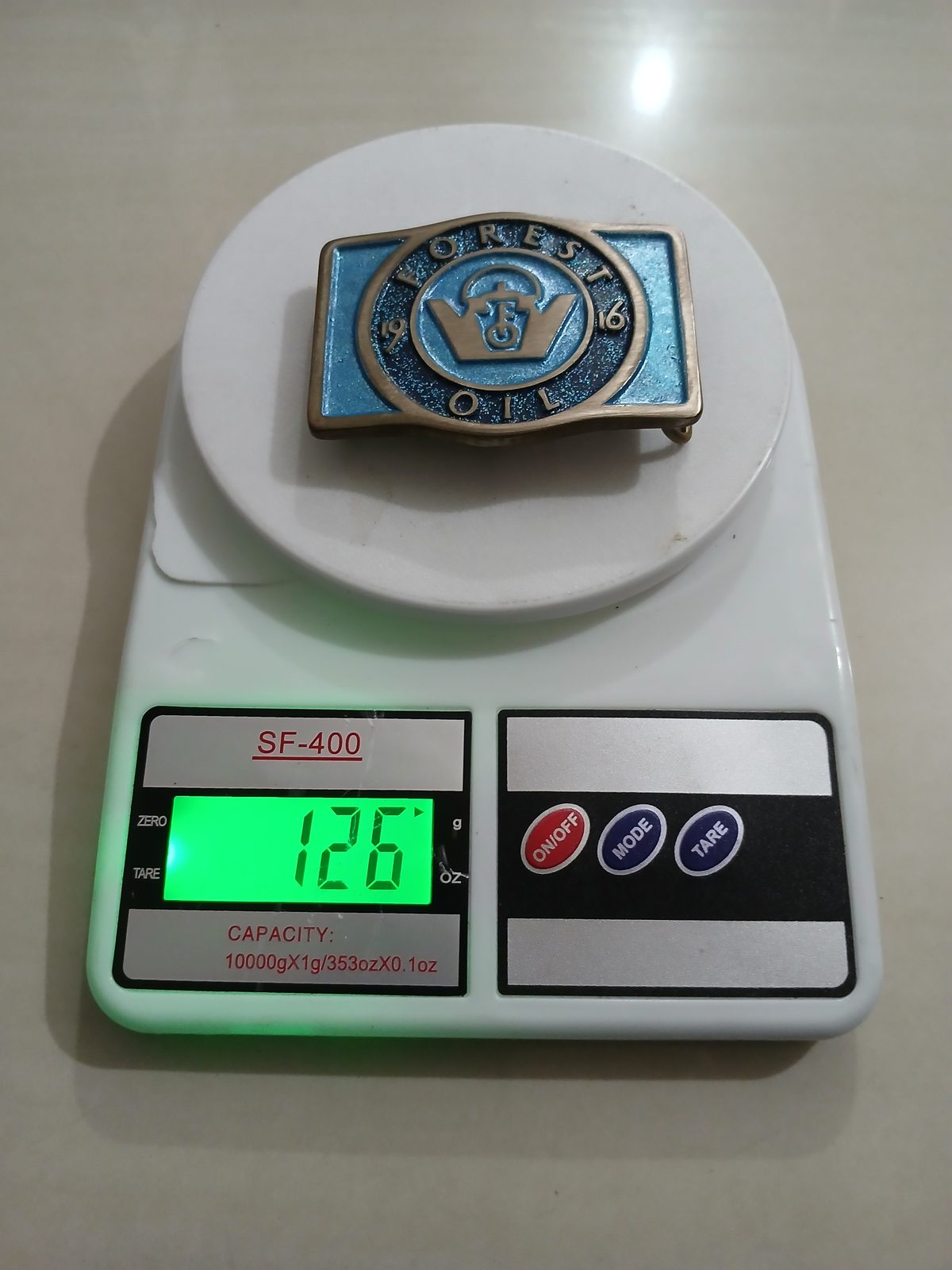 Forest Oil 1916 Vintage Belt Buckle – On scale showing weight Forest Oil 1916 vintage belt buckle – on scale showing weight