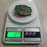 Green Floral vintage belt buckle – on scale showing weight