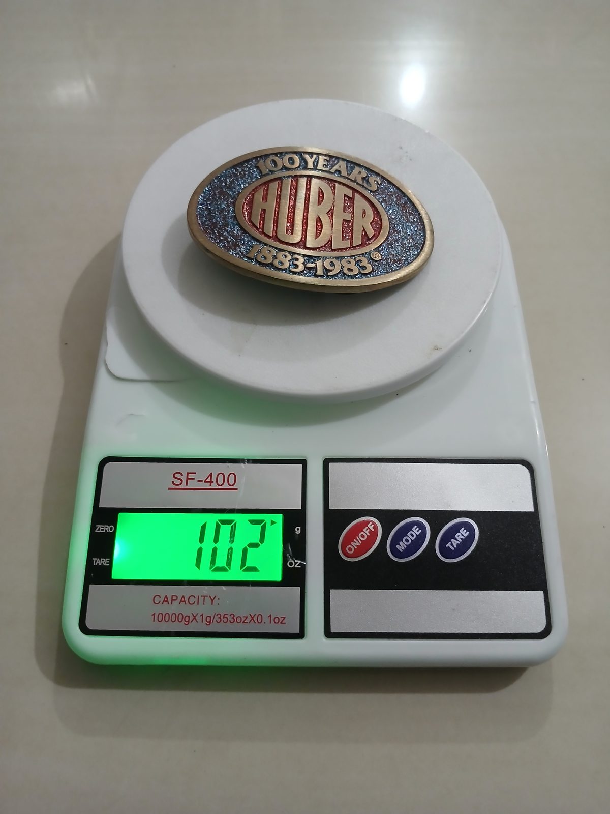 Huber 100 Years 1883-1983 Vintage Belt Buckle – On scale showing weight Huber 100 Years 1883-1983 vintage belt buckle – on scale showing weight