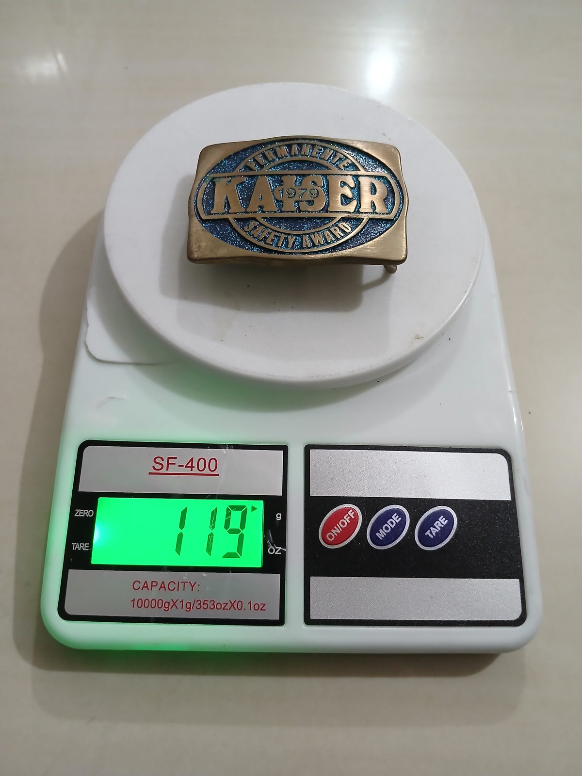 Kaiser Permanente 1979 Safety Award Vintage Belt Buckle – On scale showing weight Kaiser Permanente 1979 Safety Award vintage belt buckle – on scale showing weight
