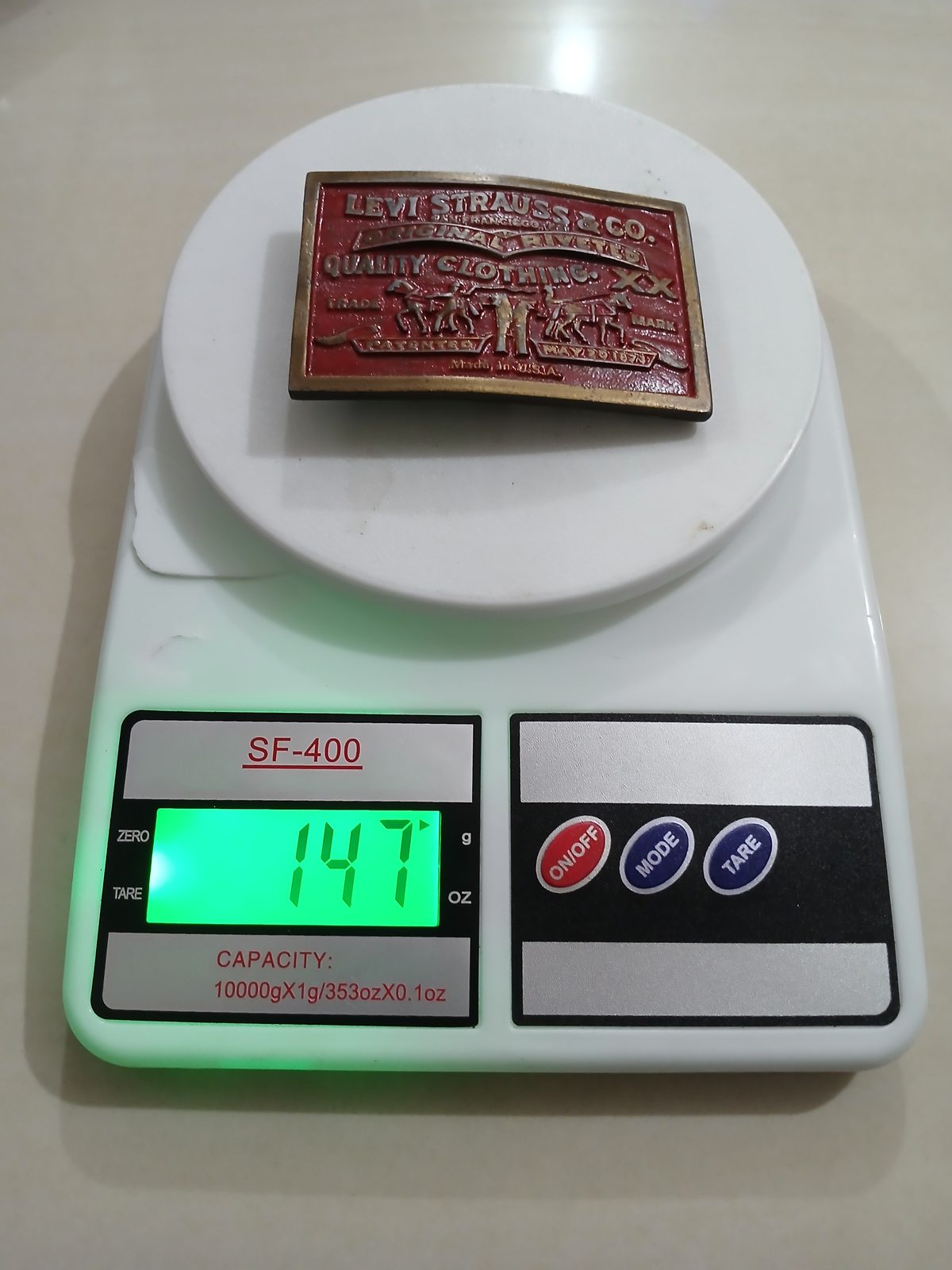 Levi Strauss Quality Clothing Vintage Belt Buckle – On scale showing weight Levi Strauss Quality Clothing vintage belt buckle – on scale showing weight