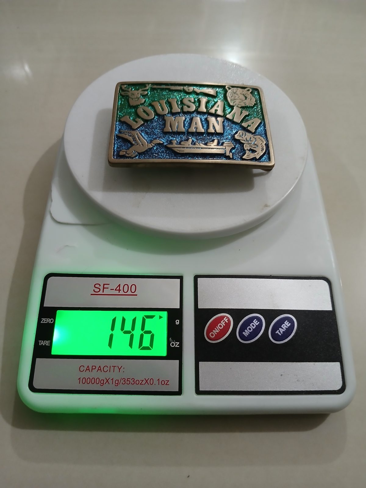 Louisiana Man Vintage Belt Buckle – On scale showing weight Louisiana Man vintage belt buckle – on scale showing weight