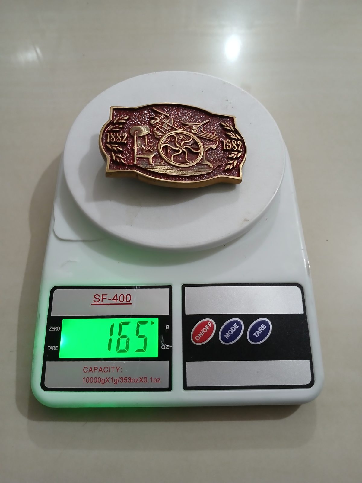 Printing Press 1882-1982 Vintage Belt Buckle – On scale showing weight Printing Press 1882-1982 vintage belt buckle – on scale showing weight
