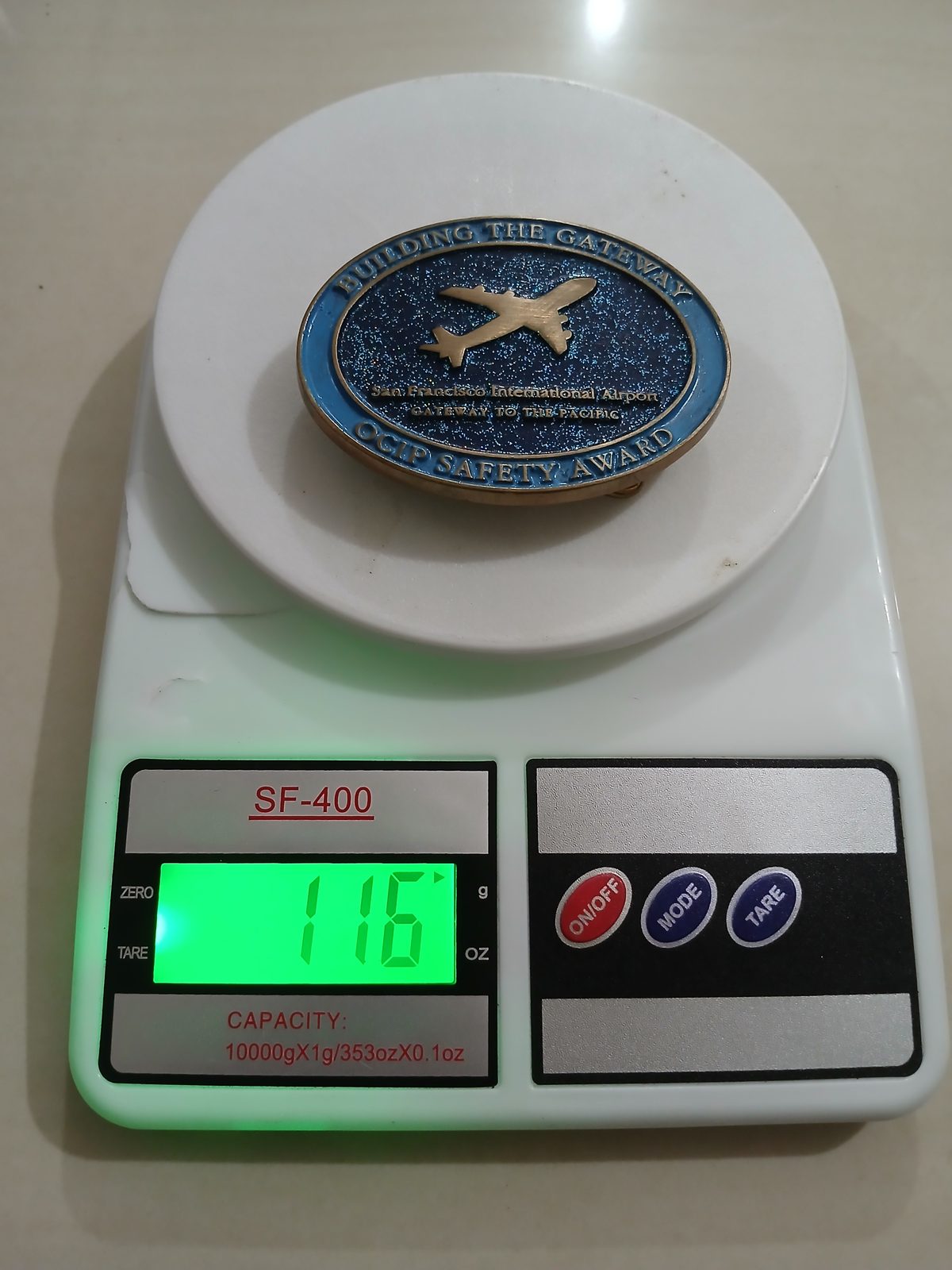 San Francisco Airport OGIP Safety Award Vintage Belt Buckle – On scale showing weight San Francisco Airport OGIP Safety Award vintage belt buckle – on scale showing weight
