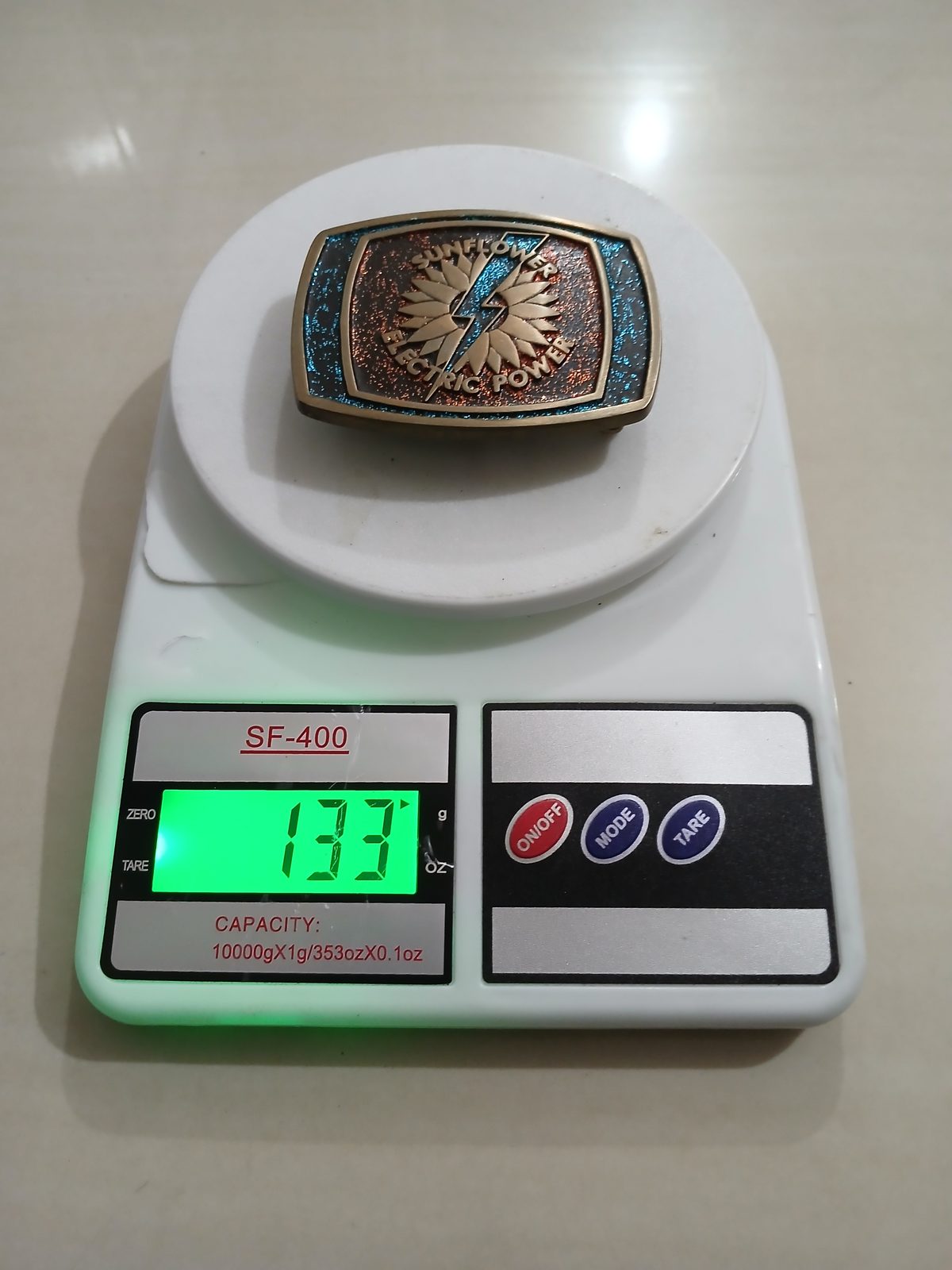 Sunflower Electric Power Vintage Belt Buckle – On scale showing weight Sunflower Electric Power vintage belt buckle – on scale showing weight