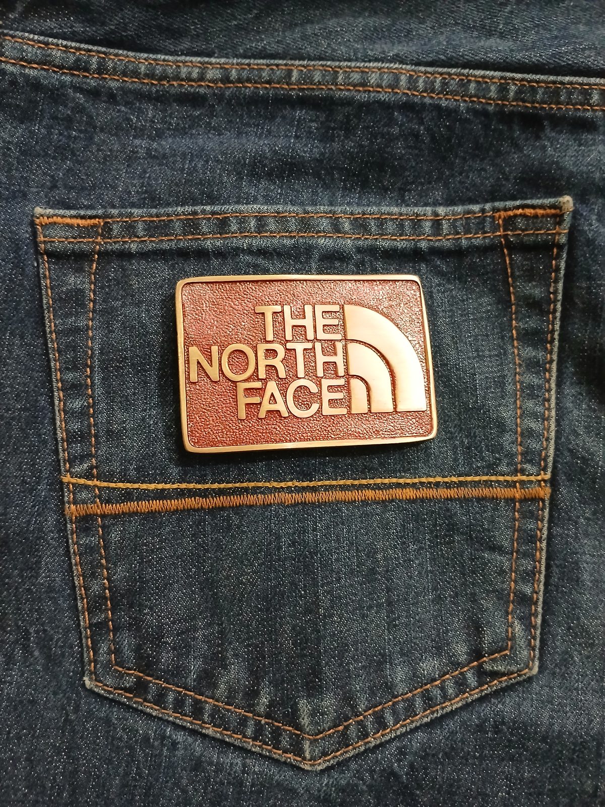 The North Face Vintage Belt Buckle – On jeans back pocket The North Face vintage belt buckle – on jeans back pocket
