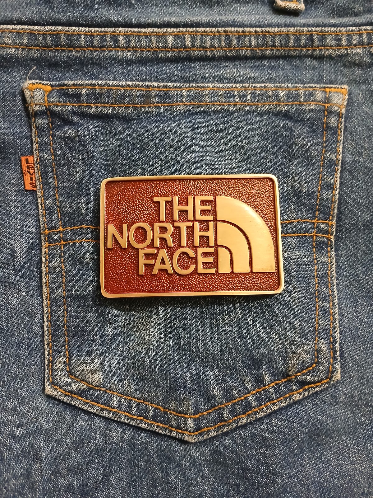 The North Face Vintage Belt Buckle – On jeans back pocket The North Face vintage belt buckle – on jeans back pocket