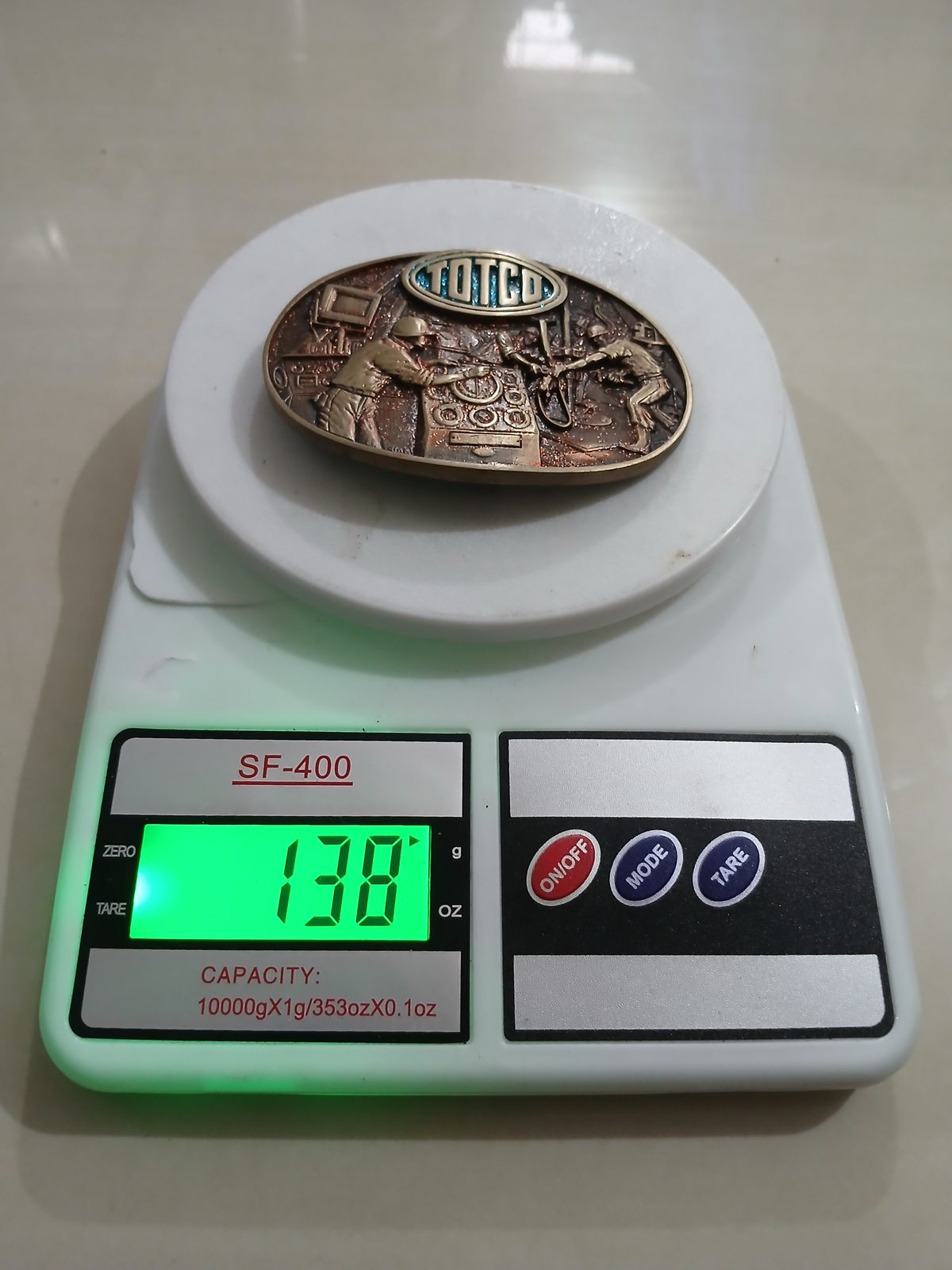 Totco Oil Workers Vintage Belt Buckle – On scale showing weight Totco Oil Workers vintage belt buckle – on scale showing weight