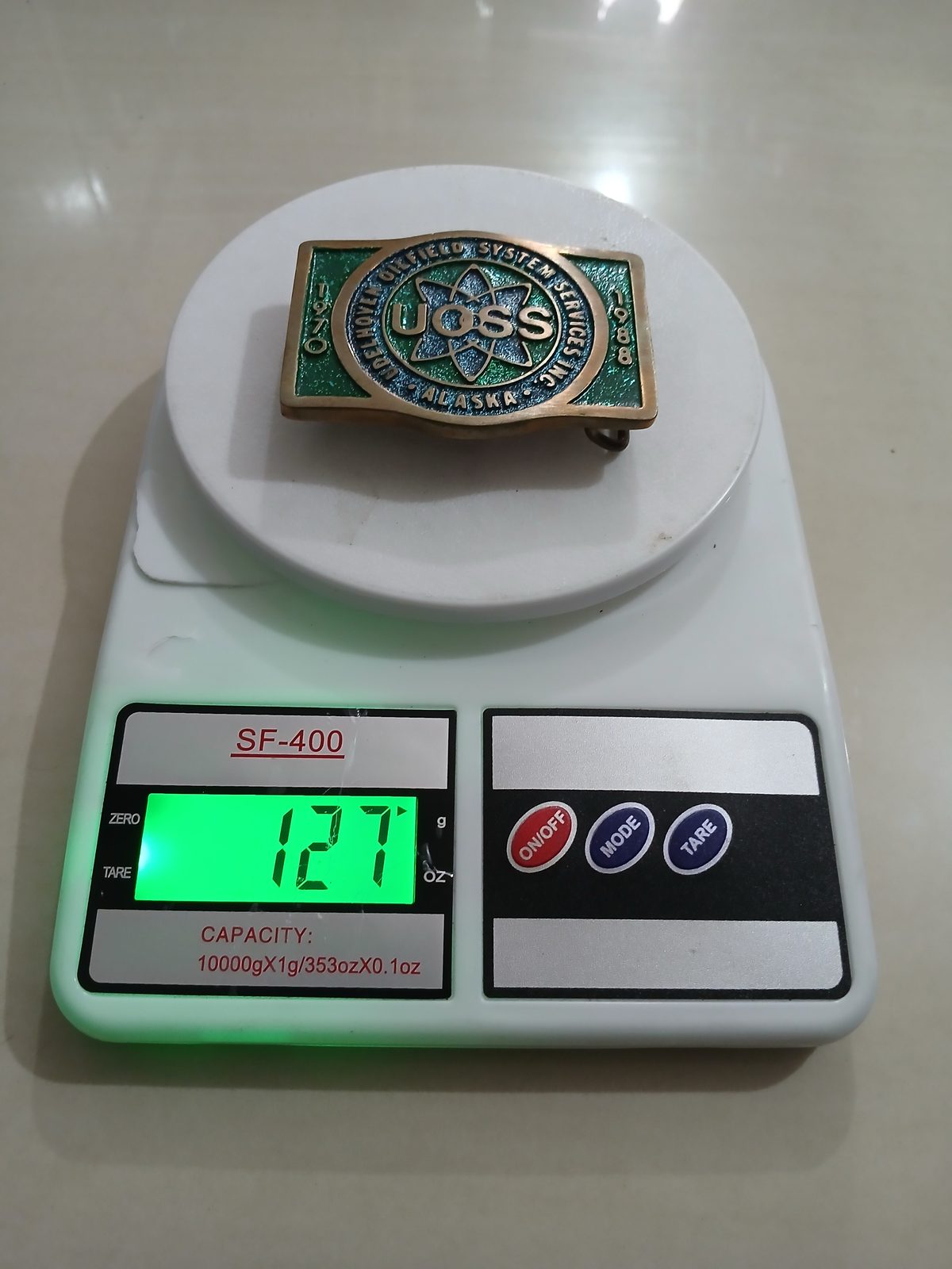 UOSS Udelhoven Oilfield Alaska Vintage Belt Buckle – On scale showing weight UOSS Udelhoven Oilfield Alaska vintage belt buckle – on scale showing weight