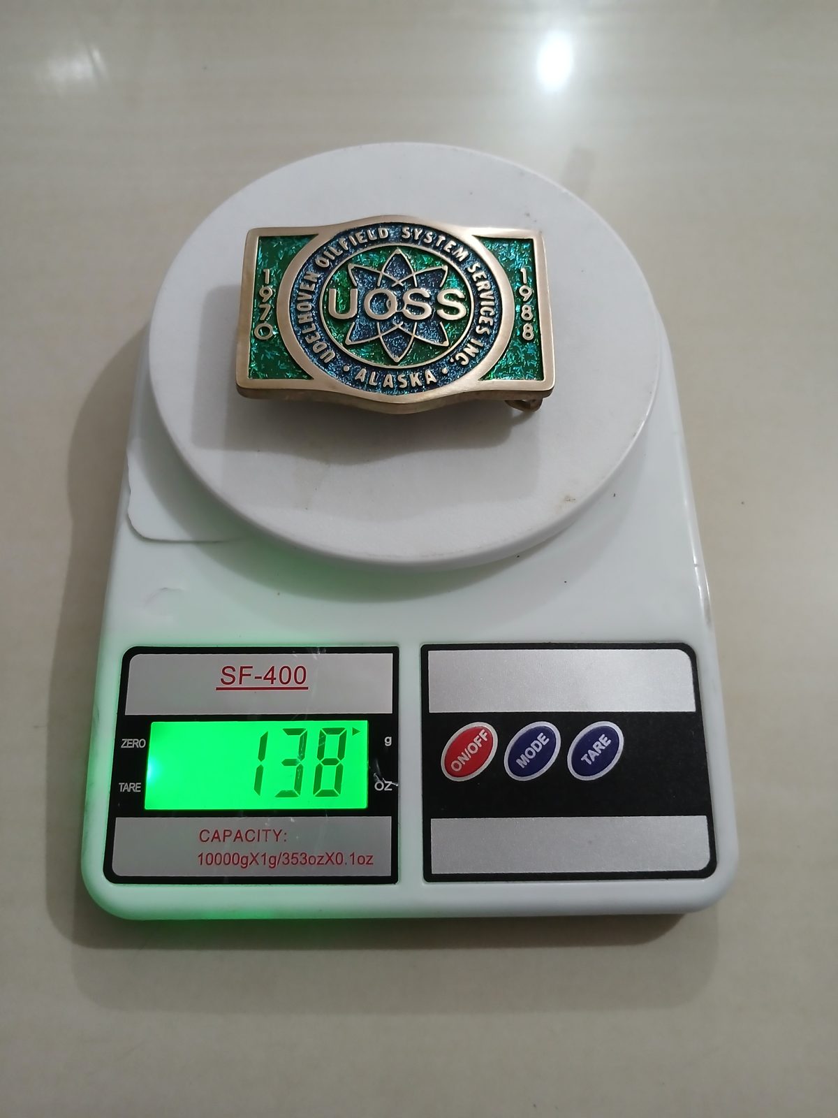 UOSS Udelhoven Oilfield Alaska Vintage Belt Buckle – On scale showing weight UOSS Udelhoven Oilfield Alaska vintage belt buckle – on scale showing weight
