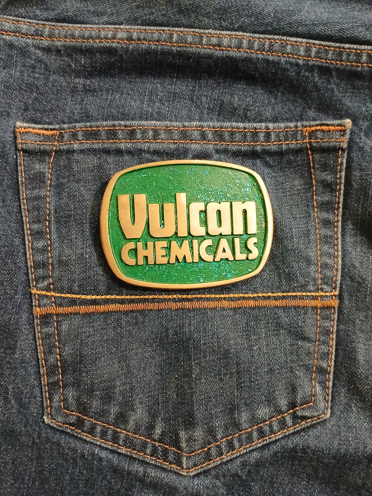 Vulcan Chemicals Vintage Belt Buckle – On jeans back pocket Vulcan Chemicals vintage belt buckle – on jeans back pocket