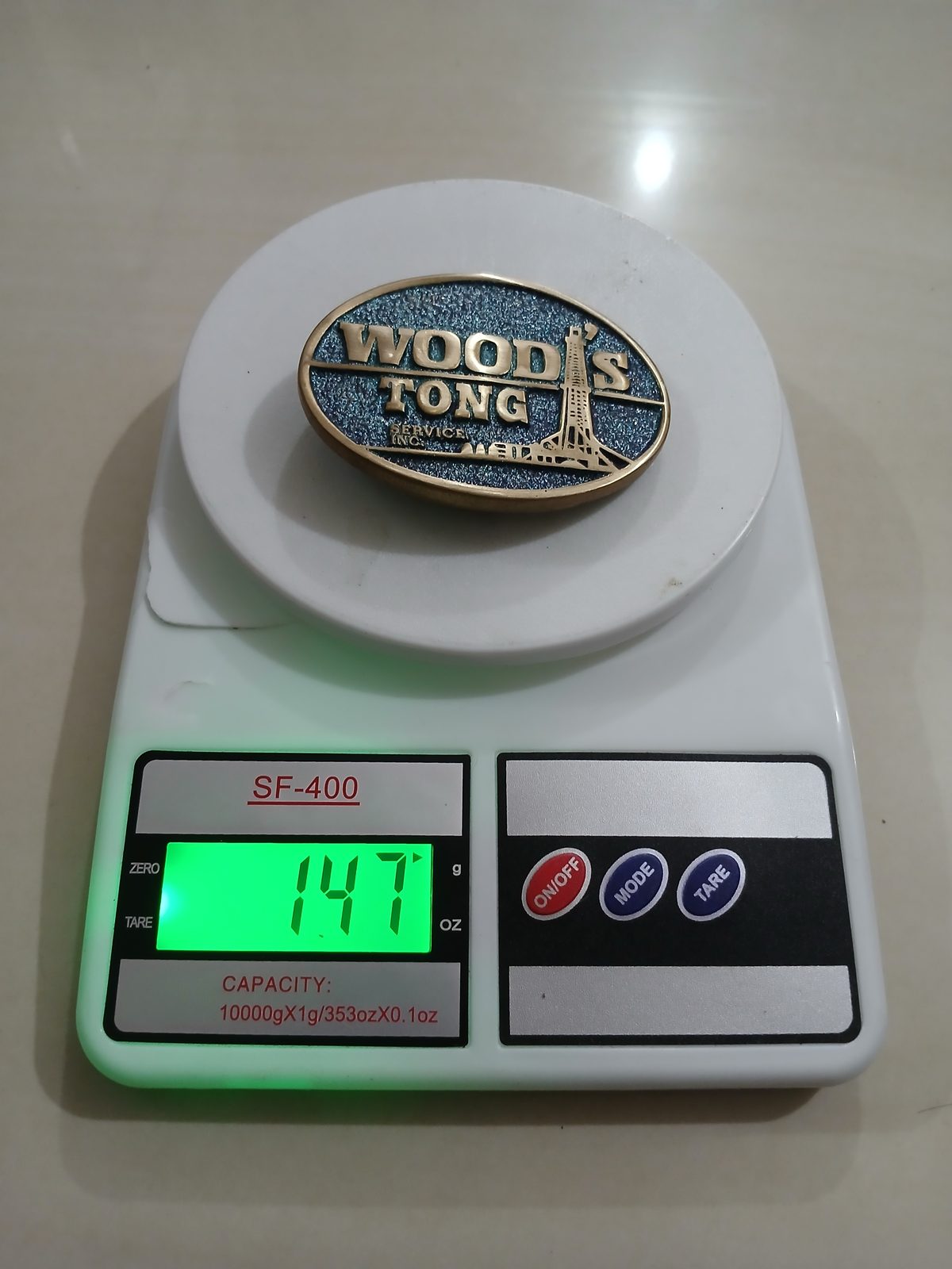 Woods Tong Service Vintage Belt Buckle – On scale showing weight Woods Tong Service vintage belt buckle – on scale showing weight
